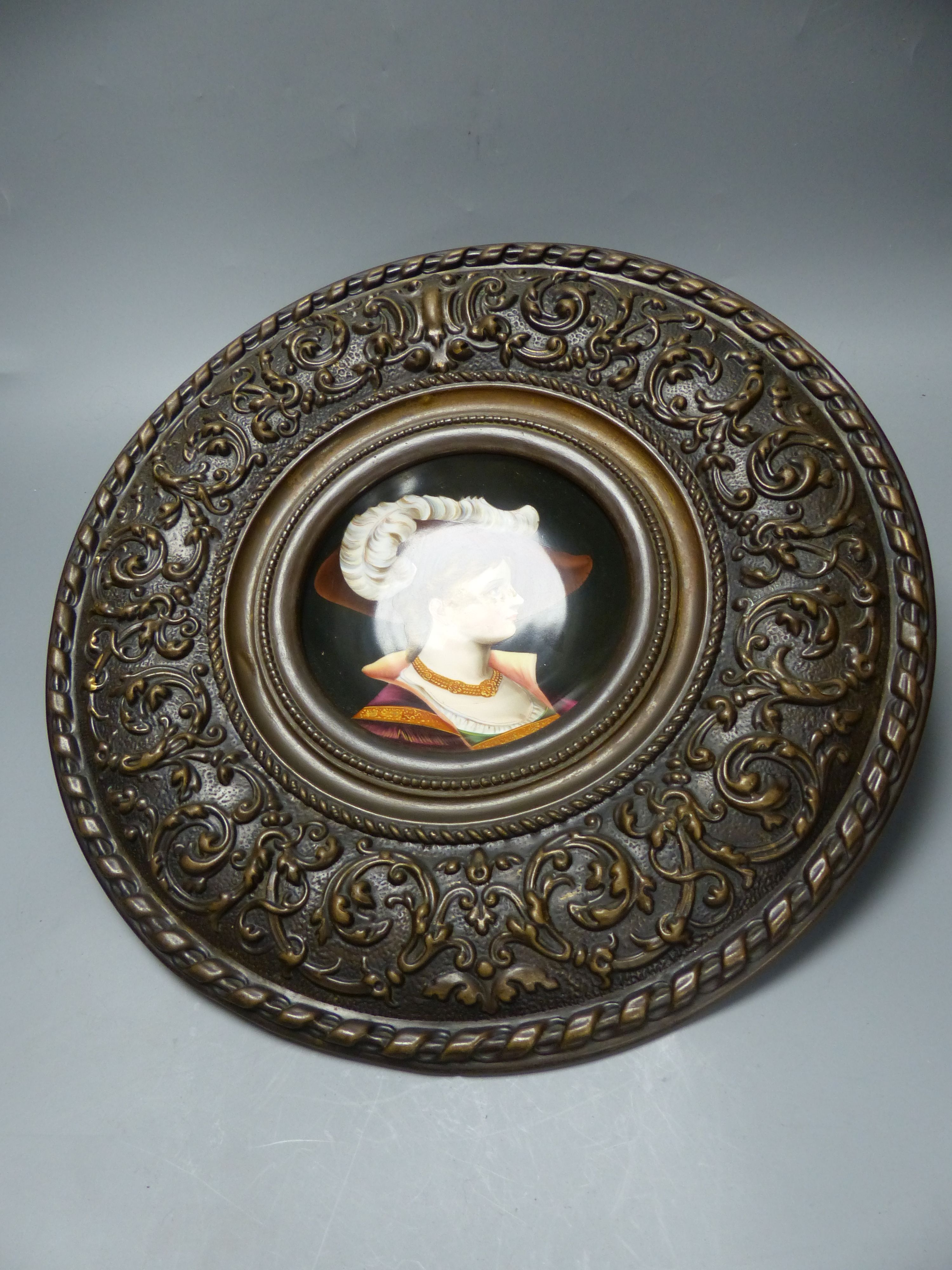 A French porcelain plaque in metal frame, overall diameter 40cm